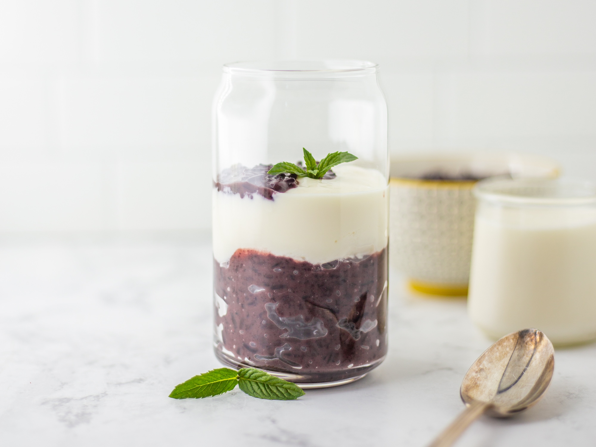 Purple sticky rice at the bottom topped with pristine white yogurt, creating a striking color contrast 